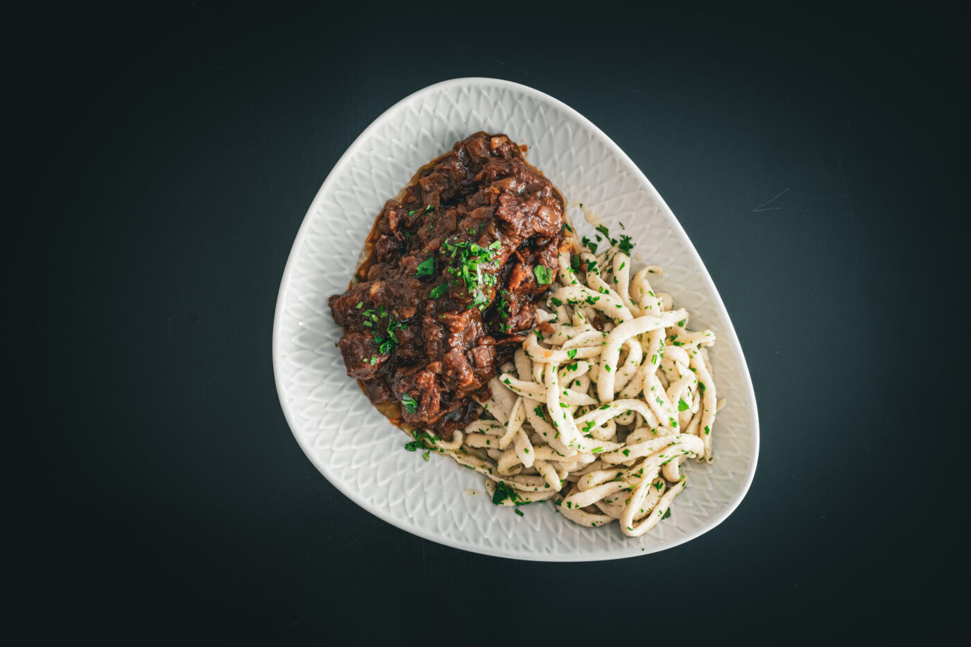 Das Bild zeigt geschortes Bioschwein mit Spätzle.